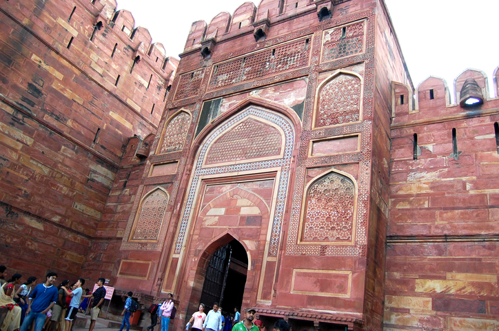       A group of people in front of the Agra Fort in India.
  