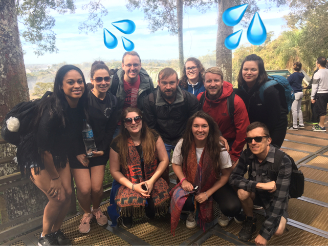 Group of people posing for a photo outdoors with added graphic elements.