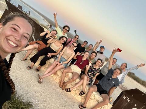       Group of people posing casually at a viewpoint.
  