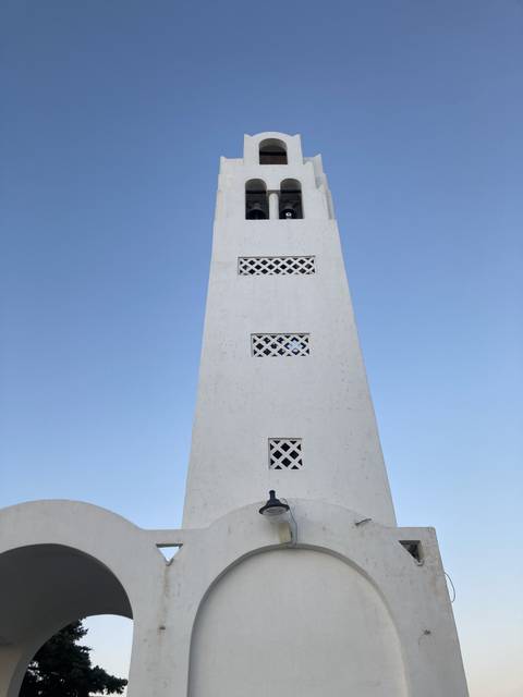 White church tower against the clear sky.