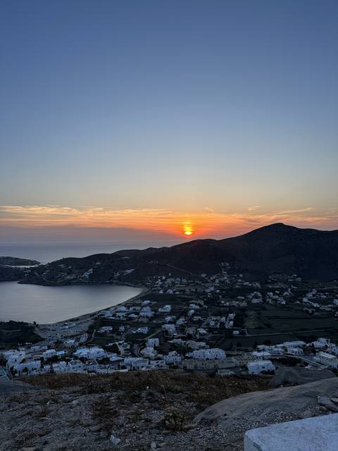 Sunset view overlooking a bay and distant mountains.