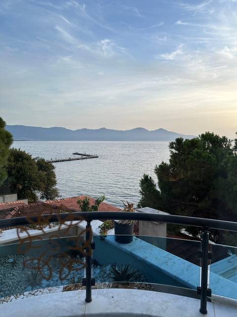 Scenic ocean view from a balcony with a metal railing.