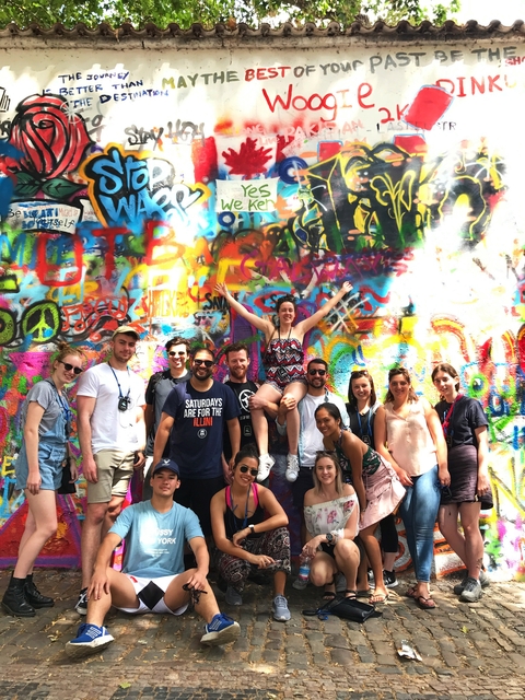 Group posing in front of colorful graffiti.
