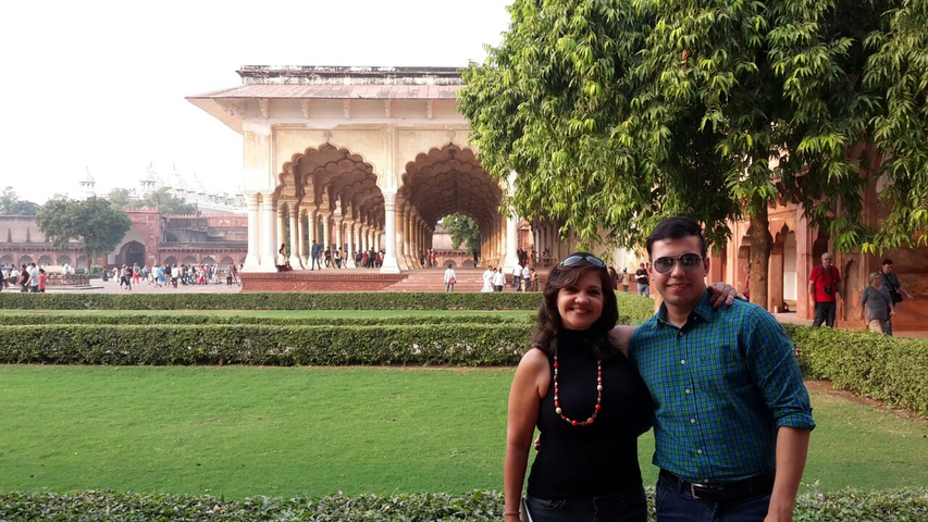       Couple posing in front of arches at a historical site.
  