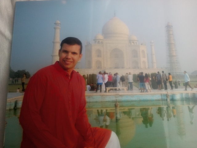       Individual posing in front of the Taj Mahal.
  