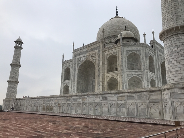 The Taj Mahal in side view with its distinctive white domes and minarets.