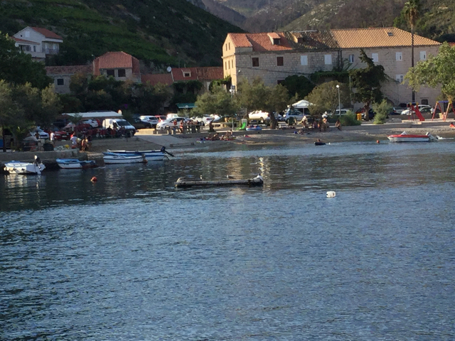 A coastal town with boats and people at the beach.