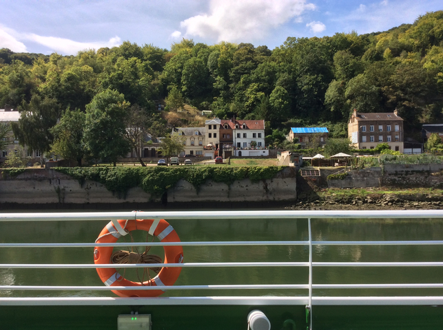 A scenic river view with houses and greenery.