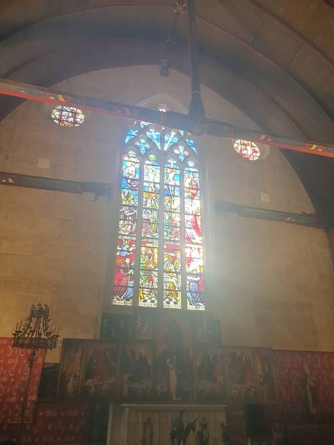       Interior stained glass window in a sunlit church.
  