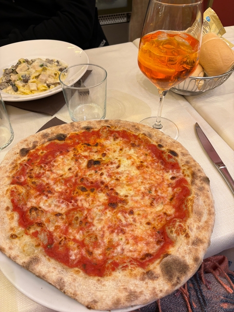 Close-up shot of a Neapolitan pizza on a table setting.