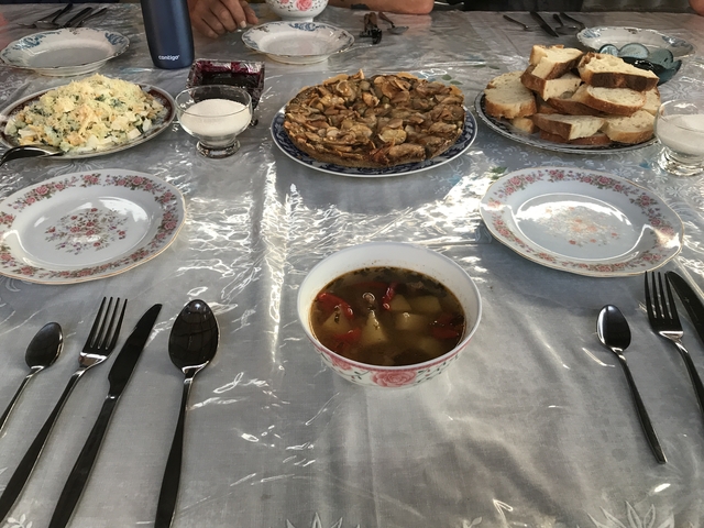       Table set with soup, bread, and various dishes.
  