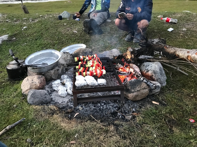       Campfire with grilling vegetables and cookware.
  
