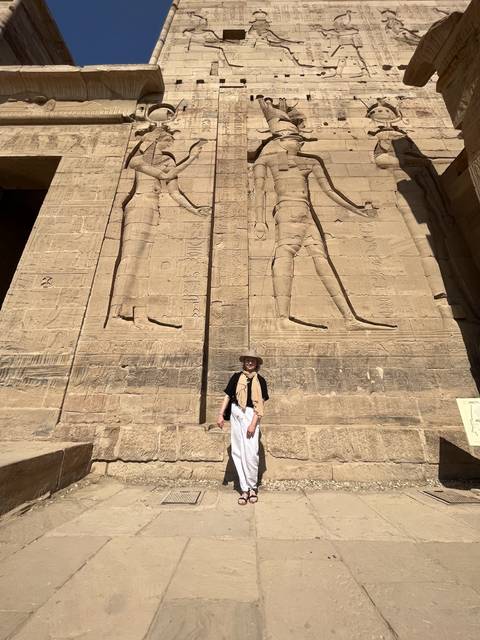       Person standing against a wall with hieroglyphics.
  