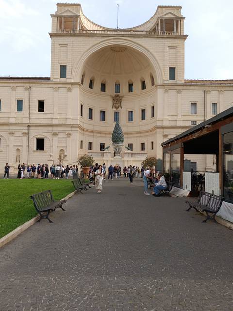 Visitors relaxing outside a significant architectural building.