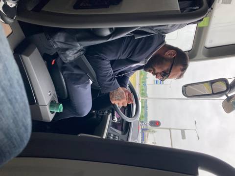 Driver in a suit inside a vehicle.