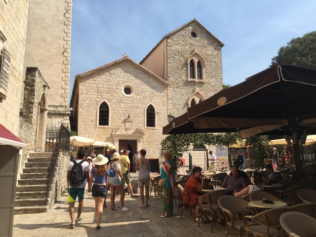       Tourists in a small quaint town area with traditional buildings.
  