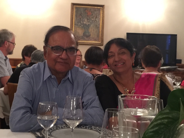       Two people sitting at a table in a restaurant setting.
  