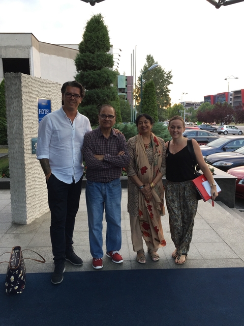       Group of four people standing together, casual setting.
  