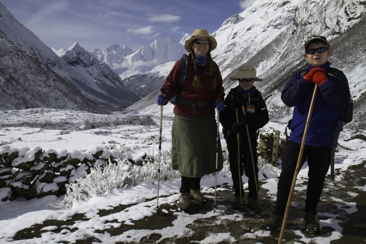 Family posing in snowy mountainous landscape.