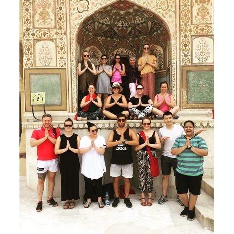 Group of people posing in front of a decorated building.
