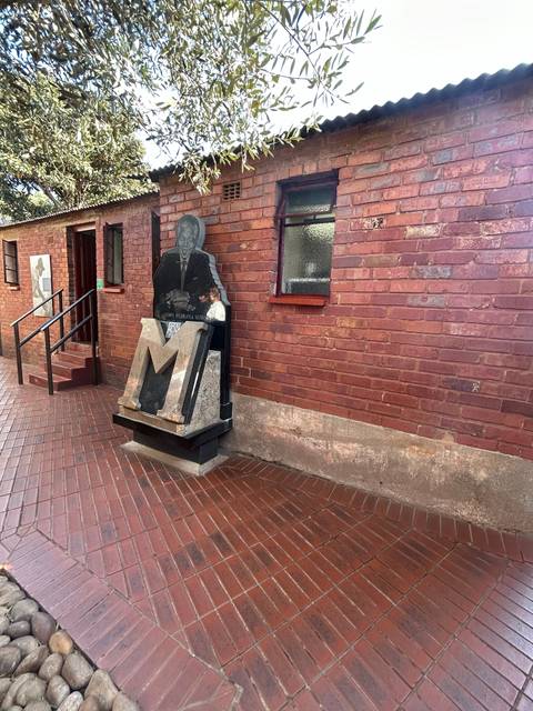 Brick building with a statue in front.