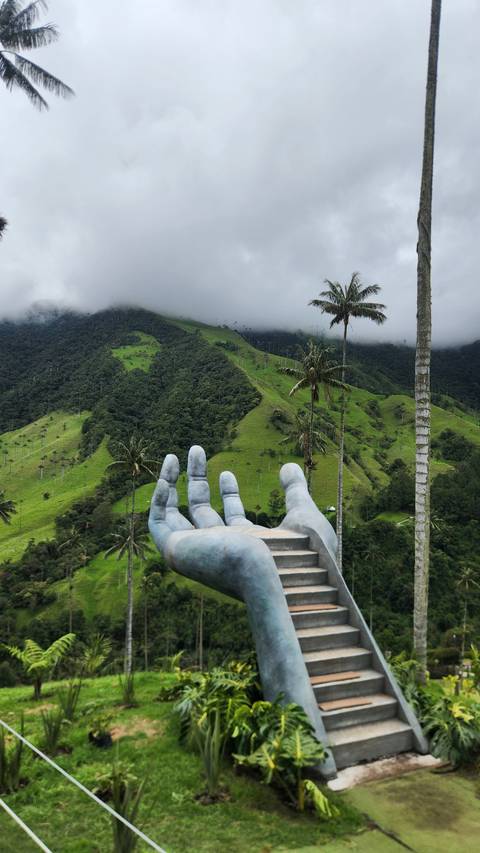       Hand-shaped platform with stairs overlooking a lush valley.
  