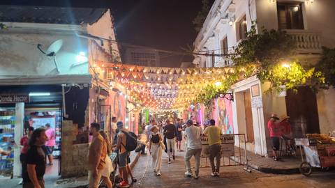       Upside-down view of a lively street with colorful lights at night.
  