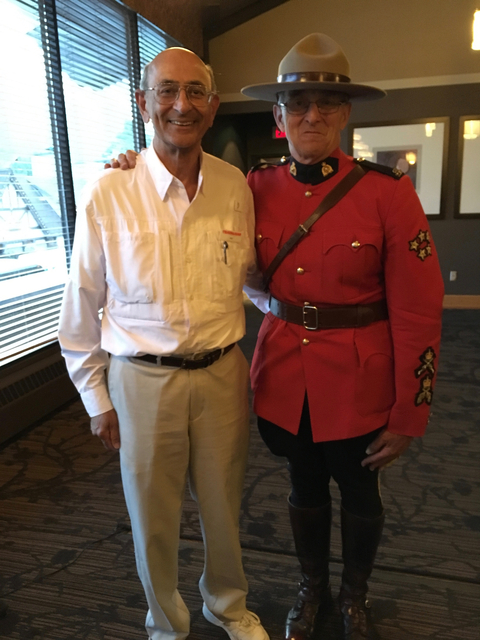 Person in uniform standing with another person indoors.