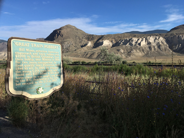 Historical sign with mountains in the background.
