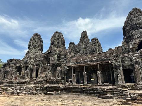 Temple ruins with exaggerated facial carvings.