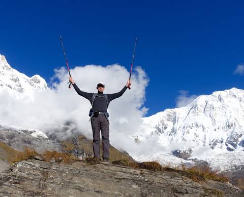       Hiker celebrating at a snowy mountain peak.
  