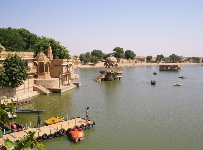       Lake with traditional architecture and boats.
  