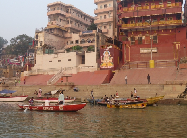 Colorful boats on a river by historic buildings.