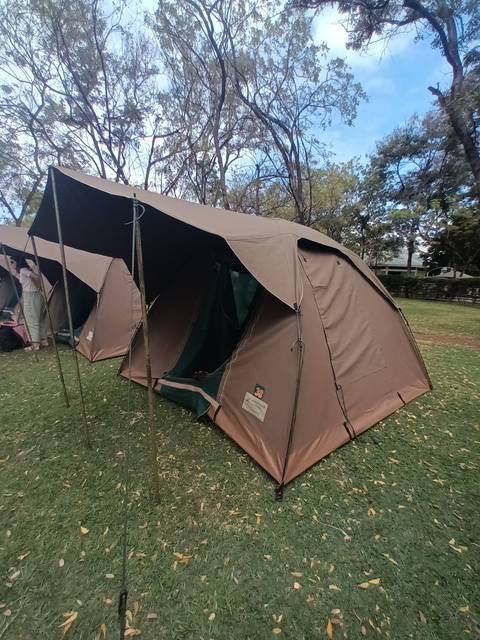 Brown camping tent set up on grass.