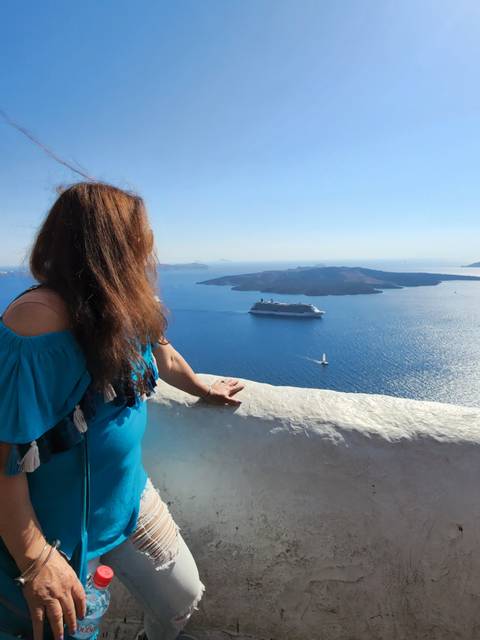       Person looking out over the sea from a clifftop.
  