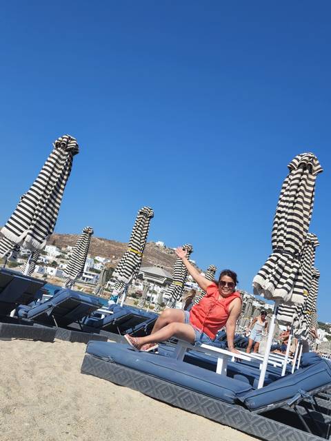       Woman posing near beach umbrellas.
  