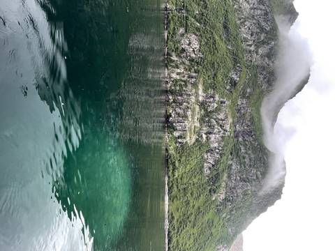      Cliff and clear water with mist.
  