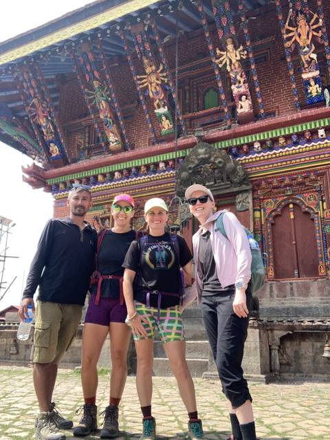       Group posing in front of a traditional building.
  