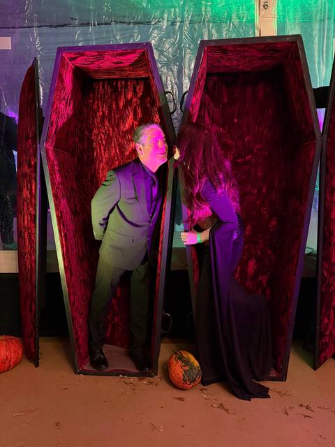 Person in a vampire-themed event, posing in a coffin.