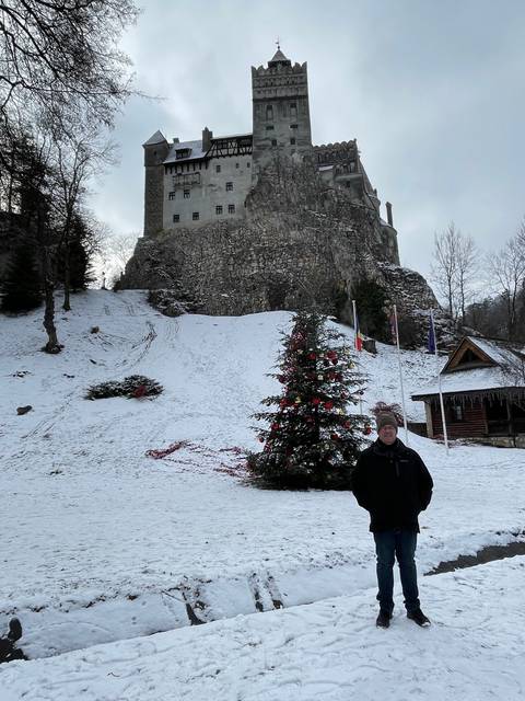 Person standing in front of a snowy castle.