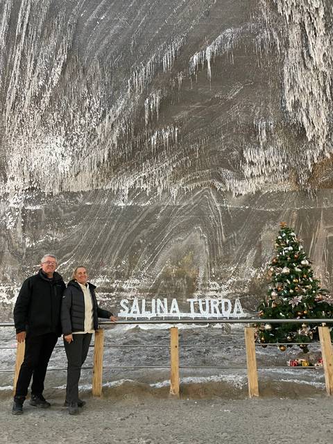 Two people in front of a sign reading 'Salina Turda'.