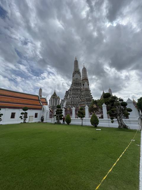 Temple complex with intricate architectural details and a grassy foreground.