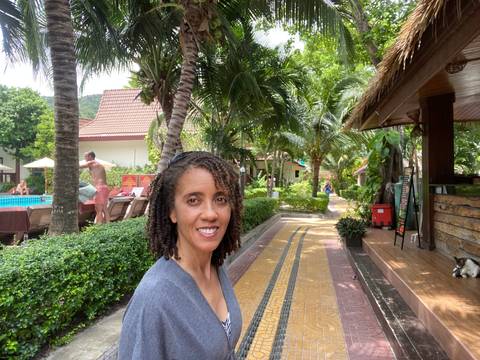 A person smiling in a garden setting.