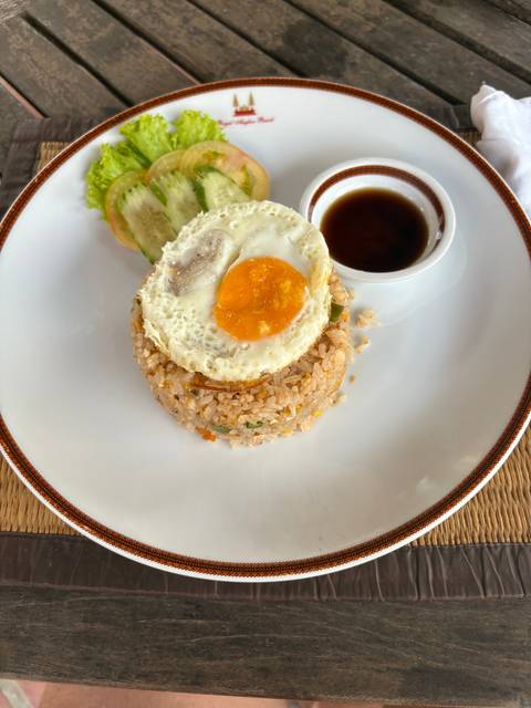       A plate of rice with a fried egg and vegetables.
  
