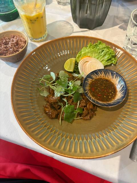       A plate of cooked meat with herbs and vegetables.
  