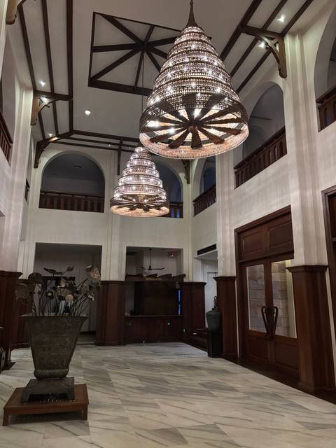       A scenic interior with chandeliers and marble flooring.
  