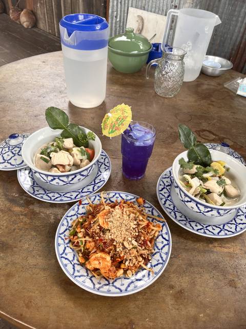 Traditional Thai dishes served on an outdoor table.