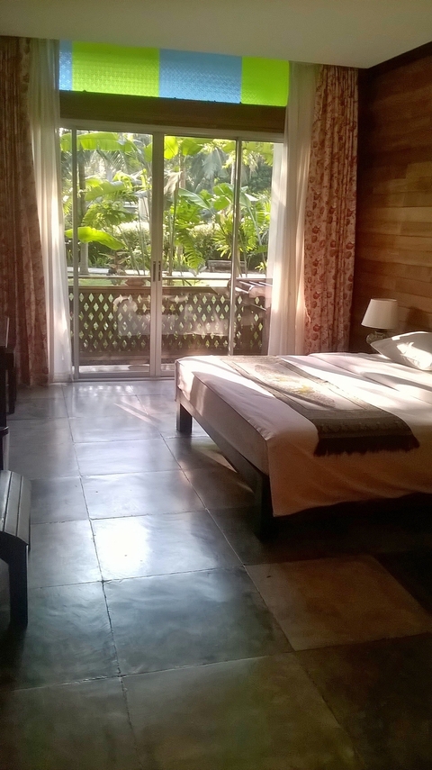 A cozy hotel room with sunlight streaming through a window.