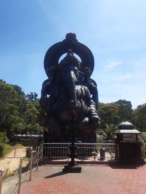       Large statue of a deity under blue skies
  