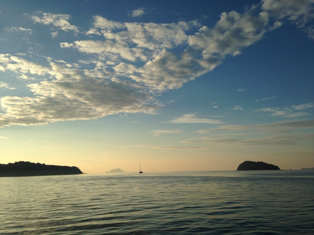 Calm sea with a boat at sunrise.